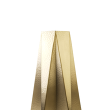 Close-up of gold stainless steel geometric vase with textured surface